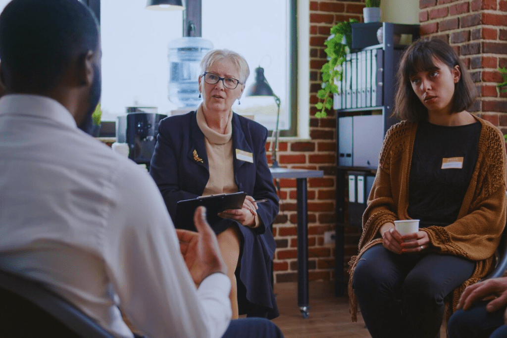 A therapist leads a discussion with individuals seeking help during a session of Georgetown, Kentucky Drug and Alcohol Rehab Resources, focusing on personalized addiction recovery support.