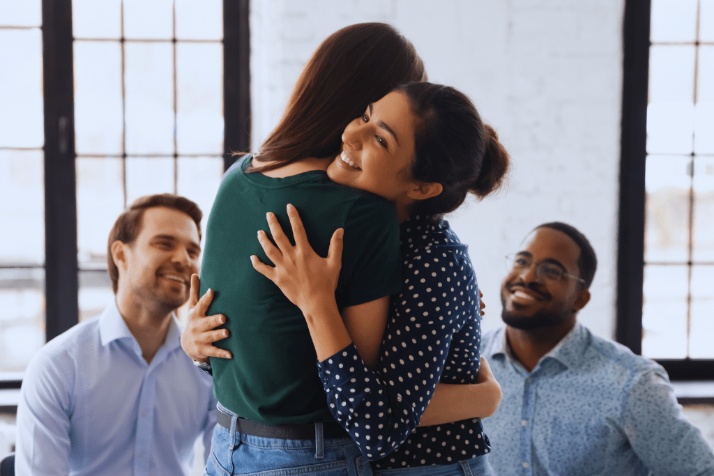 Two individuals embracing in a therapy group, showcasing the compassionate and supportive environment of Berea, Kentucky Drug and Alcohol Rehab Resources.