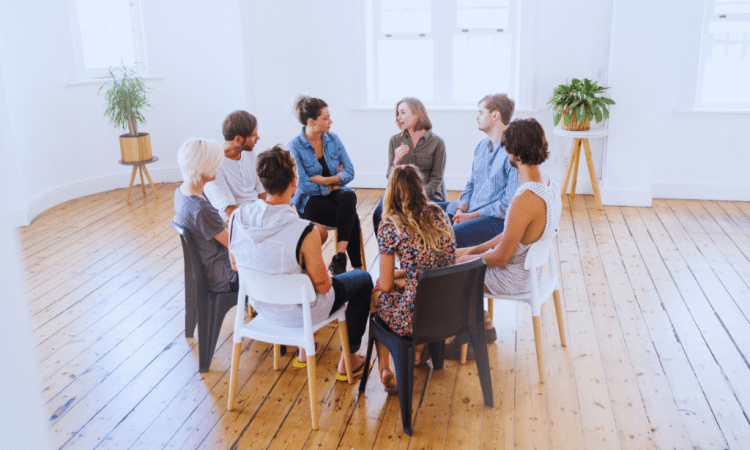 An open room with a group of individuals in a circle, attentively listening to each other at a Pikeville, Kentucky Drug and Alcohol Rehab Resources session. This setting fosters understanding and growth for participants seeking recovery.