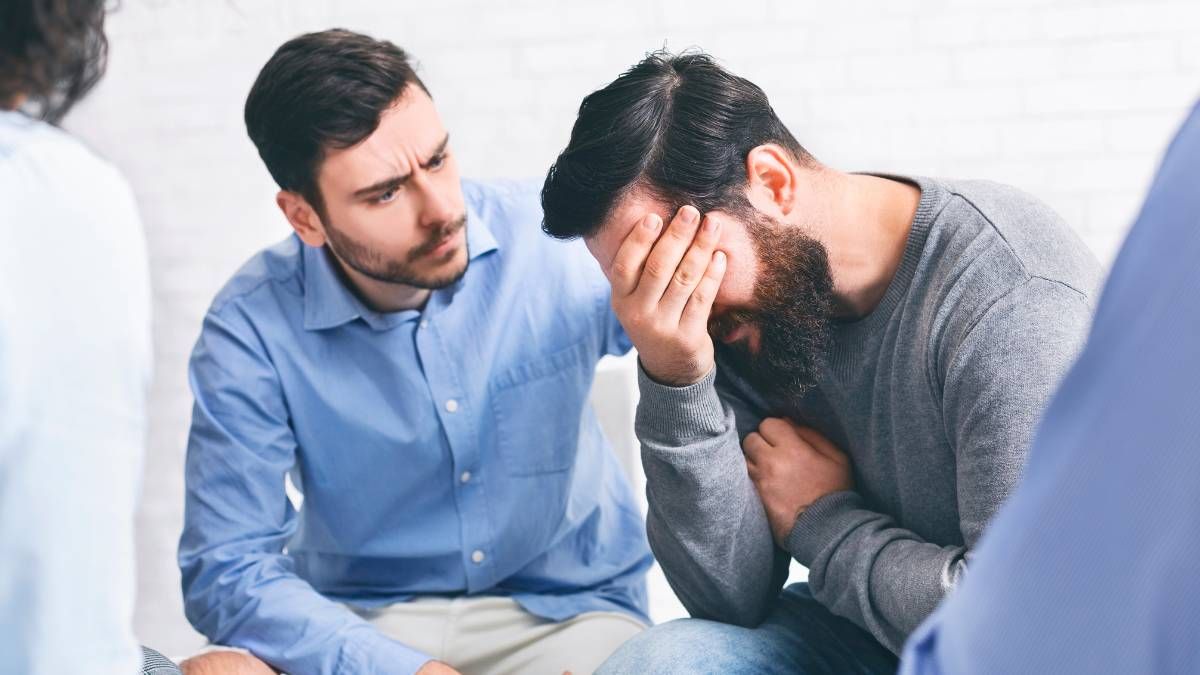 A man supporting his friend struggling with drug addiction at a drug rehab.