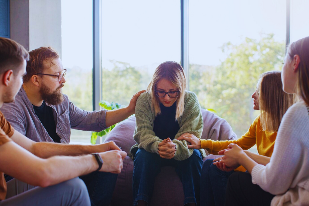 A group of people providing emotional support to a woman in distress during a session, highlighting the community aspect of Winchester, Kentucky Drug and Alcohol Rehab Resources.