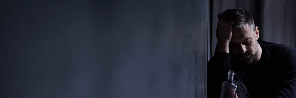 man with an addiction to alcohol caused by untreated trauma