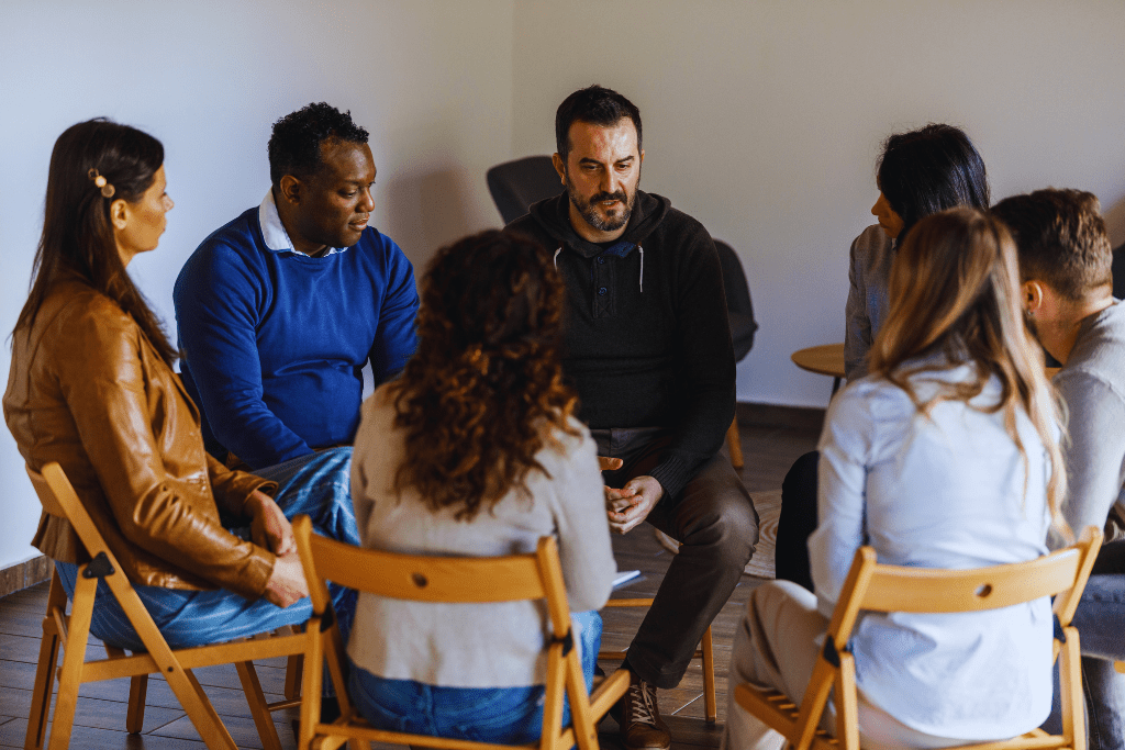 A discussion in Morehead, Kentucky Drug and Alcohol Rehab Resources: People seated in a circle in a warm, inviting room, having an in-depth conversation about recovery and support.