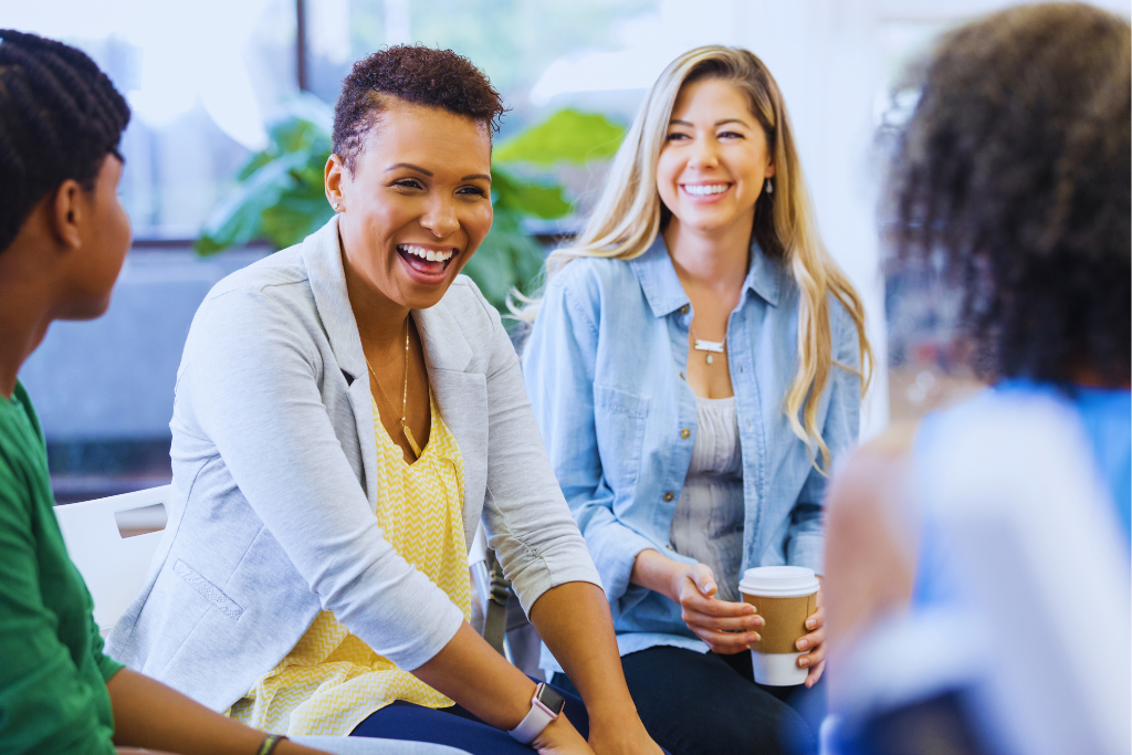 A group therapy session for Pikeville, Kentucky Drug and Alcohol Rehab Resources, where diverse individuals are laughing and engaging in a supportive conversation. The image highlights the importance of community and shared healing in addiction recovery.
