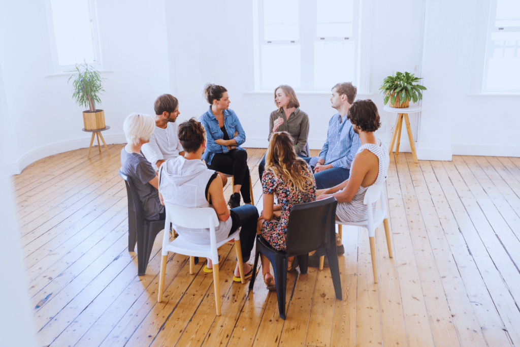 An open room with a group of individuals in a circle, attentively listening to each other at a Pikeville, Kentucky Drug and Alcohol Rehab Resources session. This setting fosters understanding and growth for participants seeking recovery.