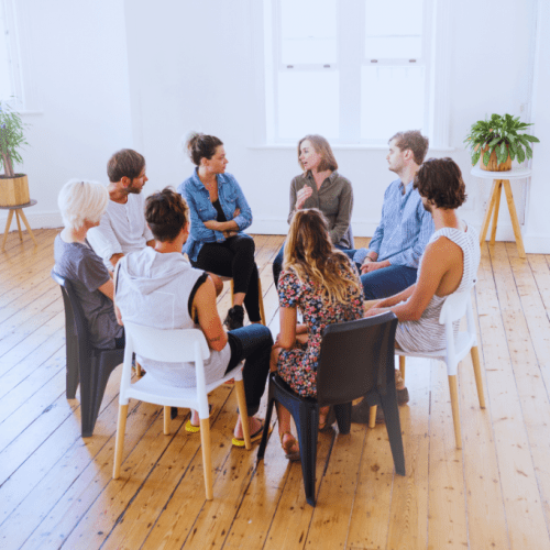 An open room with a group of individuals in a circle, attentively listening to each other at a Pikeville, Kentucky Drug and Alcohol Rehab Resources session. This setting fosters understanding and growth for participants seeking recovery.