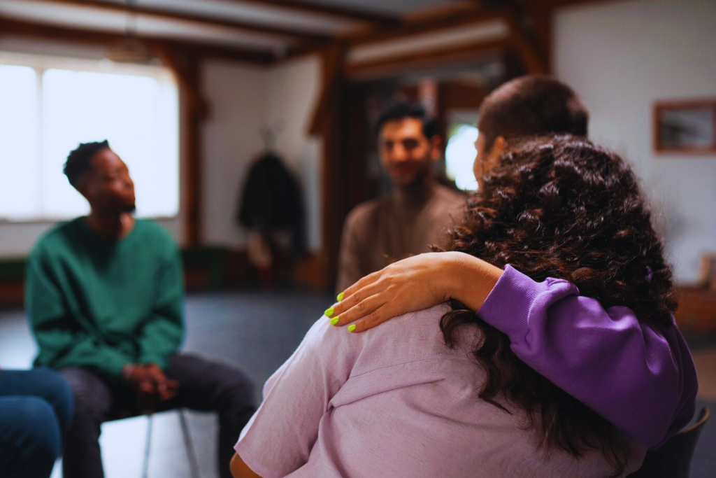 Two participants embracing in a group session, offering emotional support as part of Lawrenceburg Kentucky Drug and Alcohol Rehab Resources.