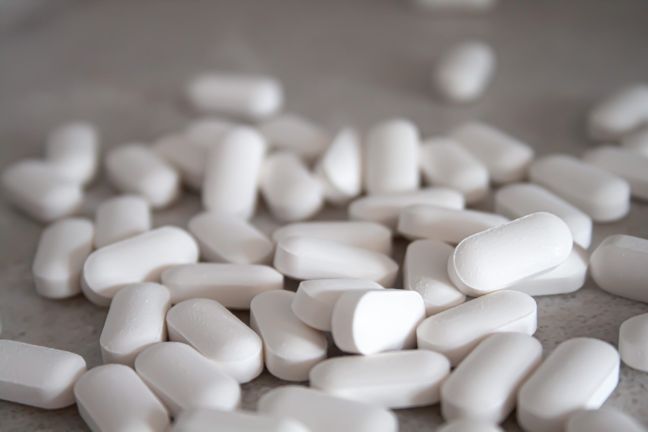 White drug tablets on a counter.