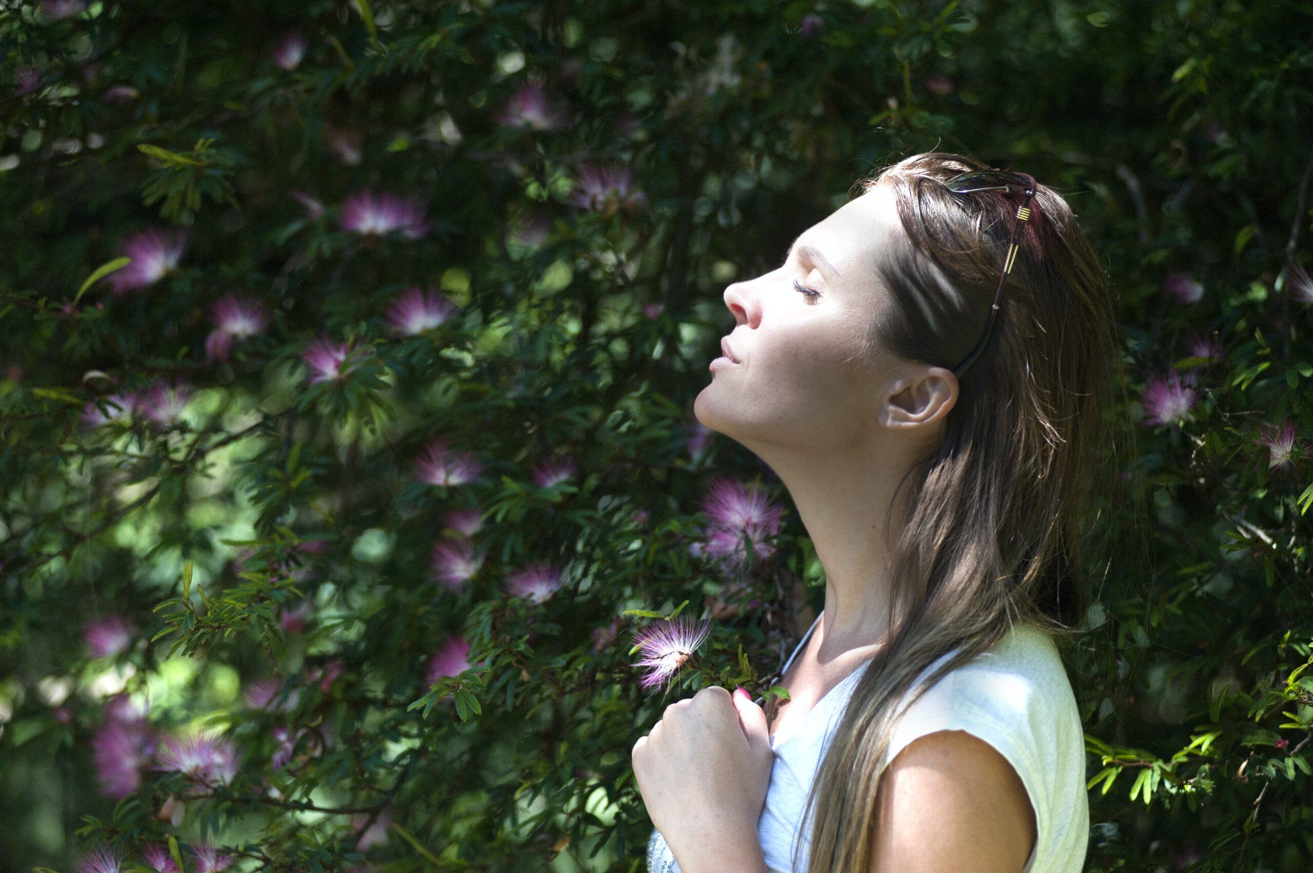 Woman stands outside in the sunshine.