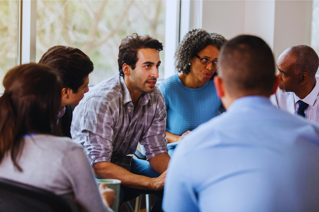A discussion at Cynthiana Kentucky Drug and Alcohol Rehab Resources, where a group of diverse individuals engages in meaningful conversation, sharing personal stories and receiving support for addiction recovery.