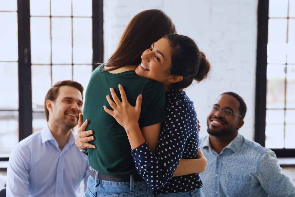 Two individuals embracing in a therapy group, showcasing the compassionate and supportive environment of Berea, Kentucky Drug and Alcohol Rehab Resources.
