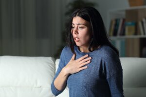 woman with an anxiety disorder is cluthing her chest during a panic attack