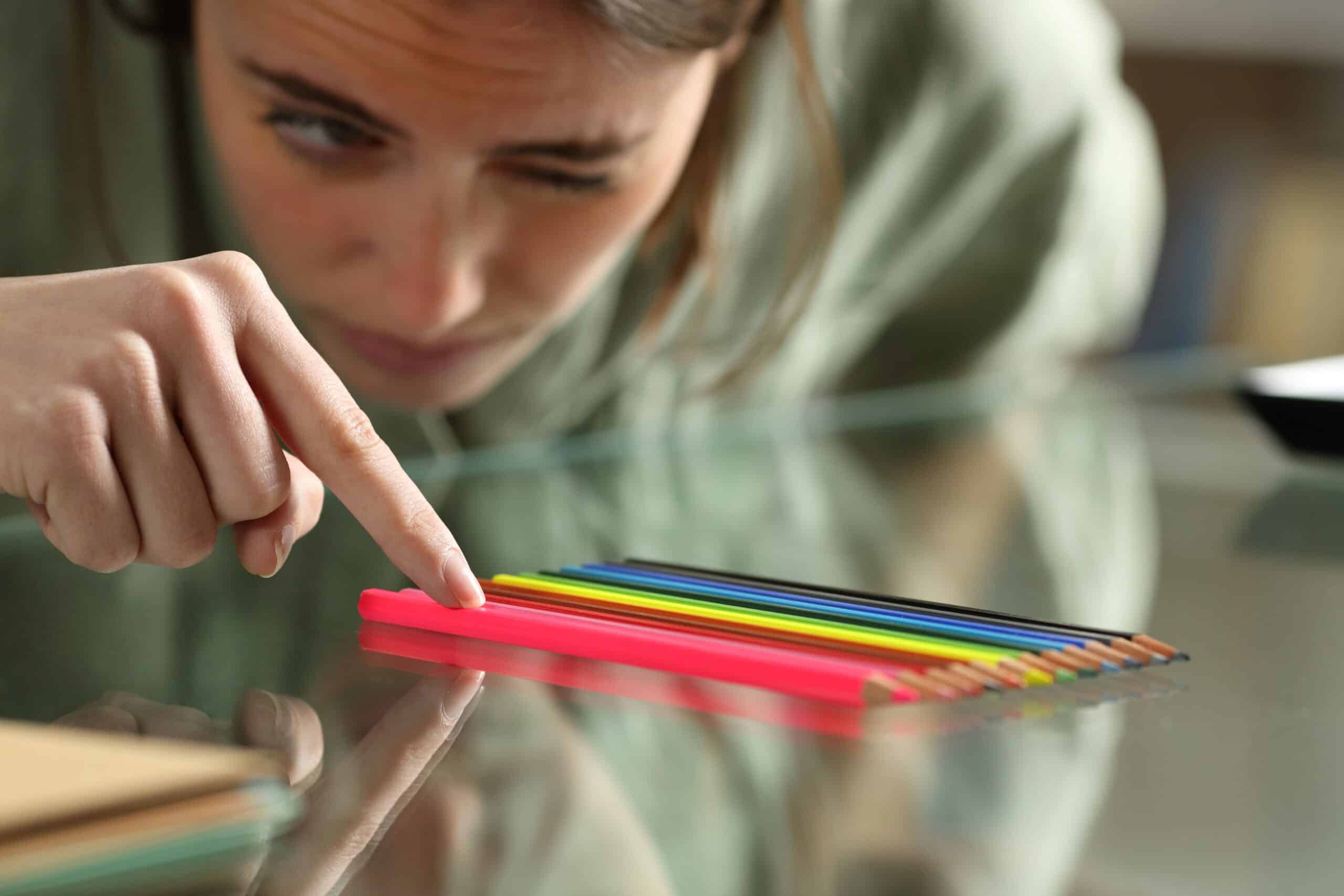 client with OCD arranges pencils on a desk