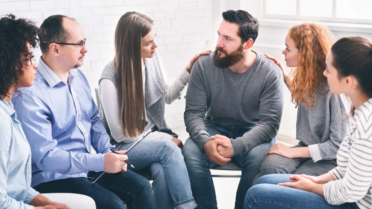 Group of people discussing how drug rehab works during therapy. 