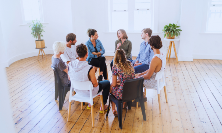 An open room with a group of individuals in a circle, attentively listening to each other at a Pikeville, Kentucky Drug and Alcohol Rehab Resources session. This setting fosters understanding and growth for participants seeking recovery.